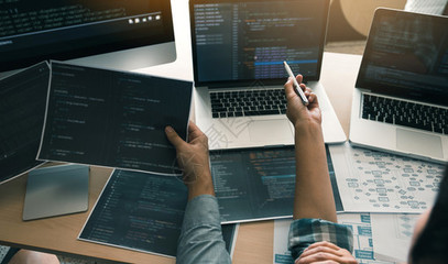 两名软件开发商正在使用计算机与其办公桌的合作伙伴